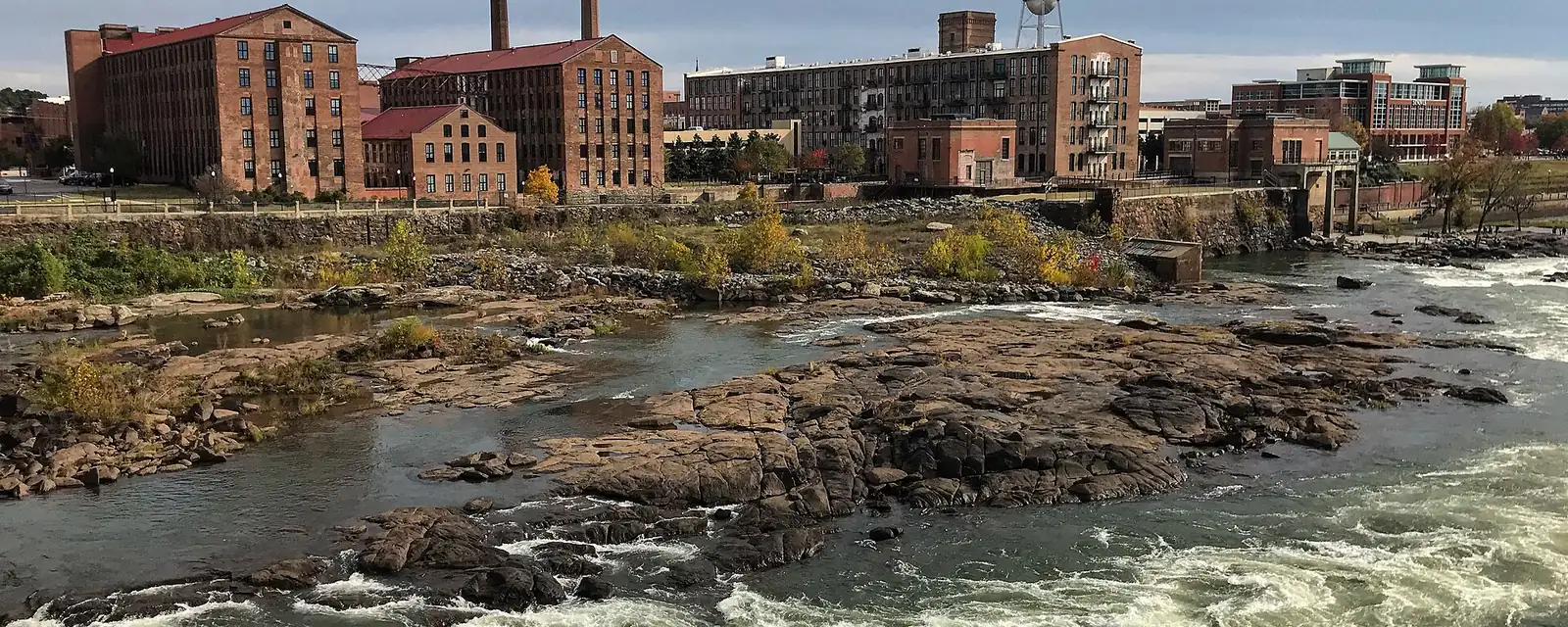 The Chattahoochee River rapids beside old brick mills in Columbus, Georgia